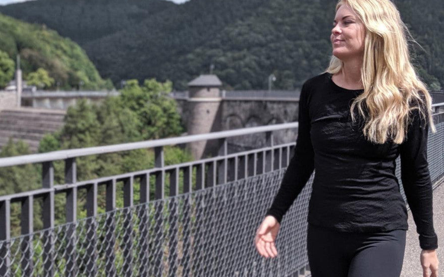 woman wearing black alpaca t shirt long sleeved walking near a dam