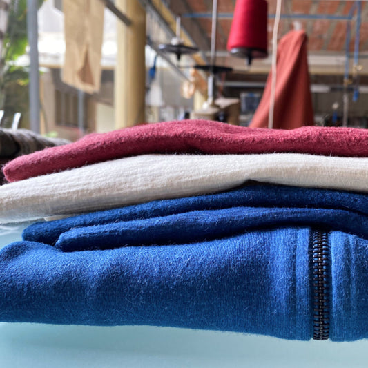 pile of Arms of Andes alpaca wool outdoor apparel in the workshop