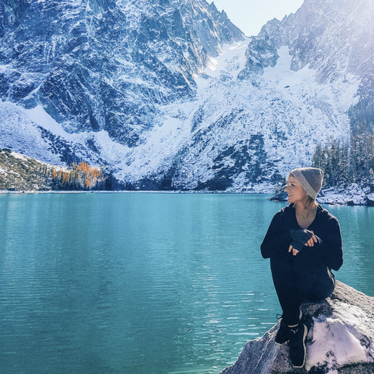 Woman wearing alpaca wool clothing near glacier lake