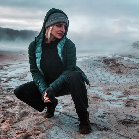 Woman wearing layered outdoor clothing in a geothermal area in iceland