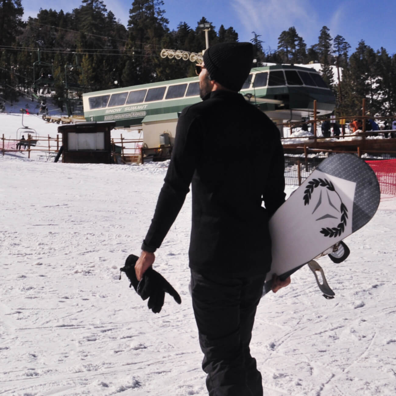 man carrying snowboard and wearing  alpaca wool base layer